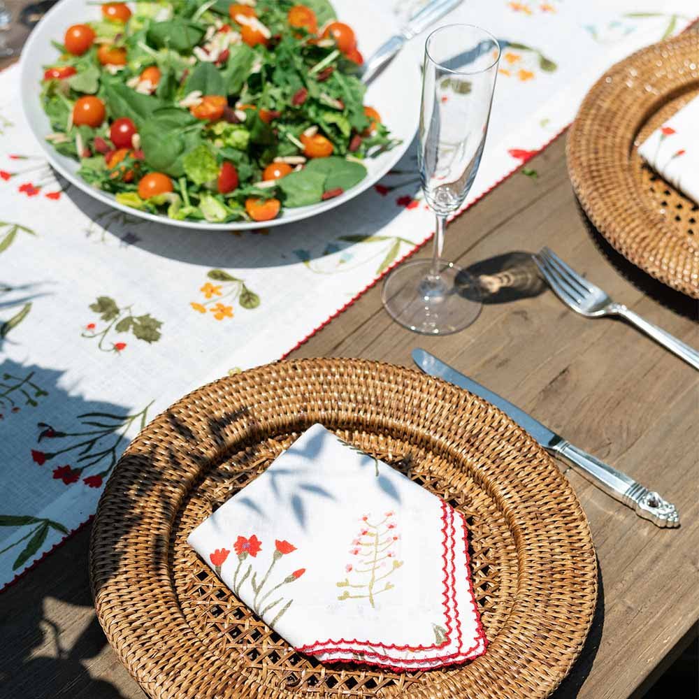 Napkin and table runner on outdoor table with salad. 