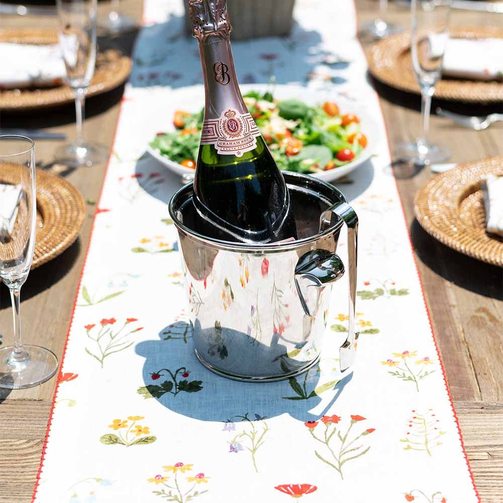 Table runner on dinner table with wine and salad. 