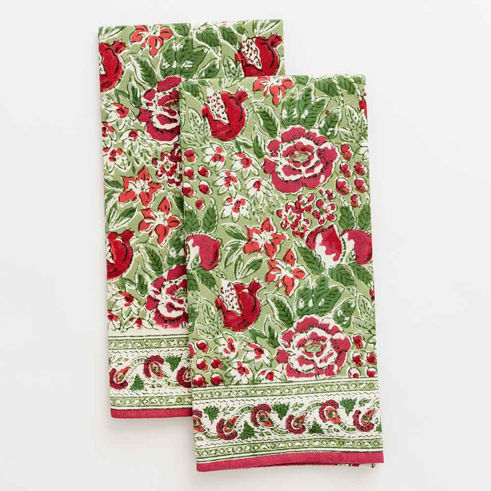 Floral printed tea towels consisting of hues of raspberry, moss, and fern. 