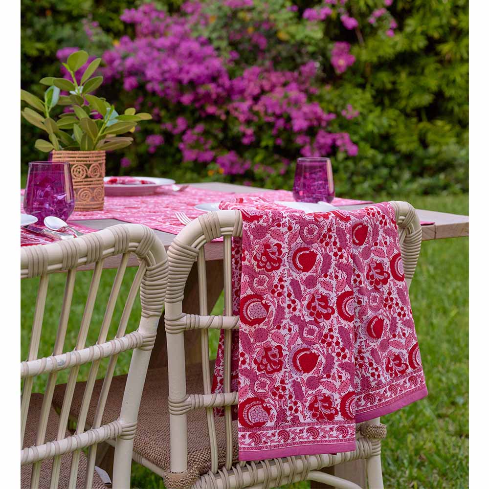 Tea towel hanging on back of chair with complementary flowers in background. 