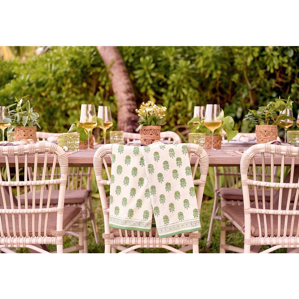 Tea towel set draped on the back of a chair at an outdoor dinner table. 