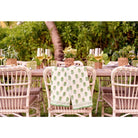 Tea towel set draped on the back of a chair at an outdoor dinner table. 