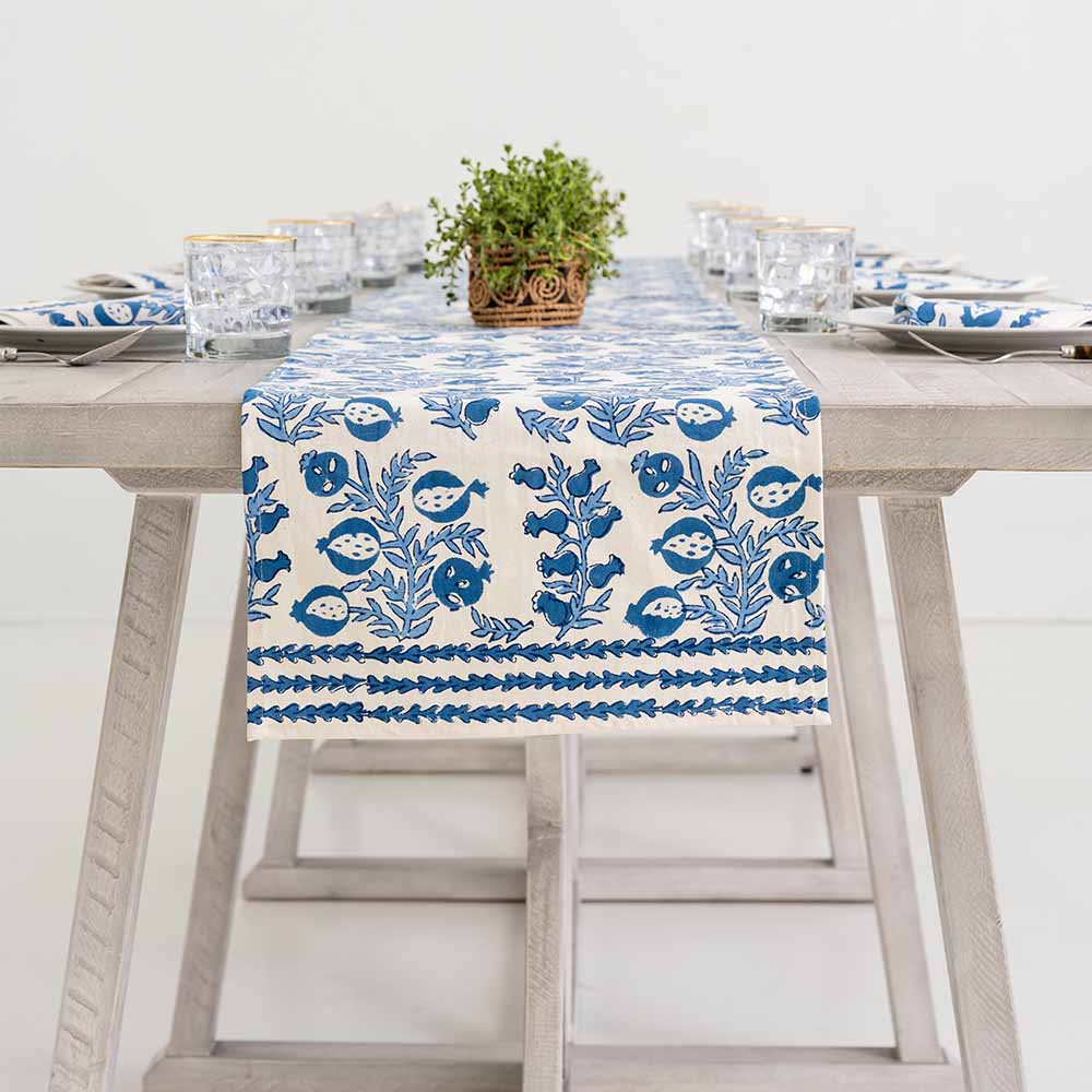 Blue and white pattern table runner decorating middle of dinner table. 