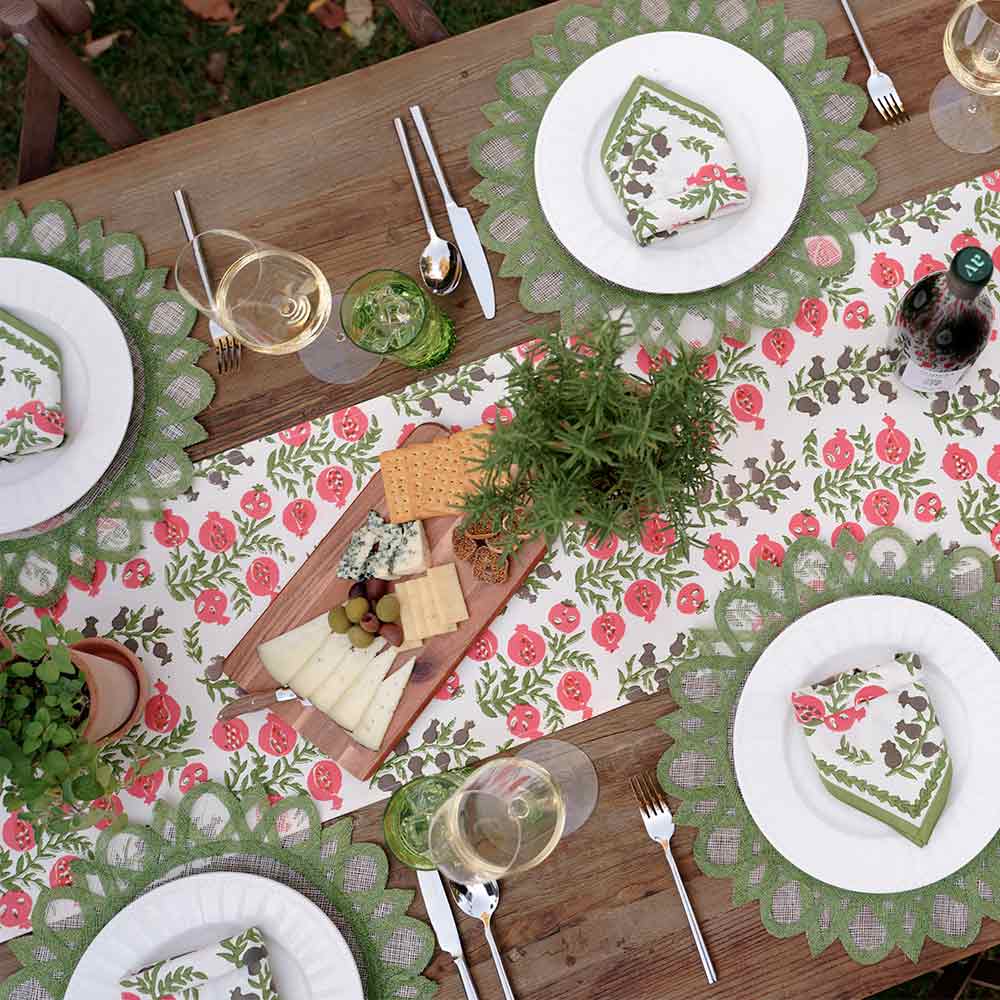 Overhead shot of table runner and matching napkins on white plate. 