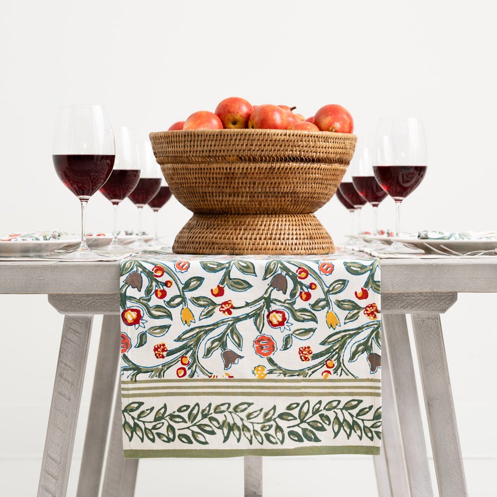 table runner with floral pattern in shades of sage green, crimson, marigold and deep orange