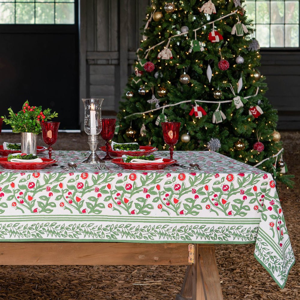 Table with Emma red and green tablecloth in front of Christmas tree