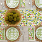 Close up of Emma table runner on dinner table decorated with basket and green centerpiece. 