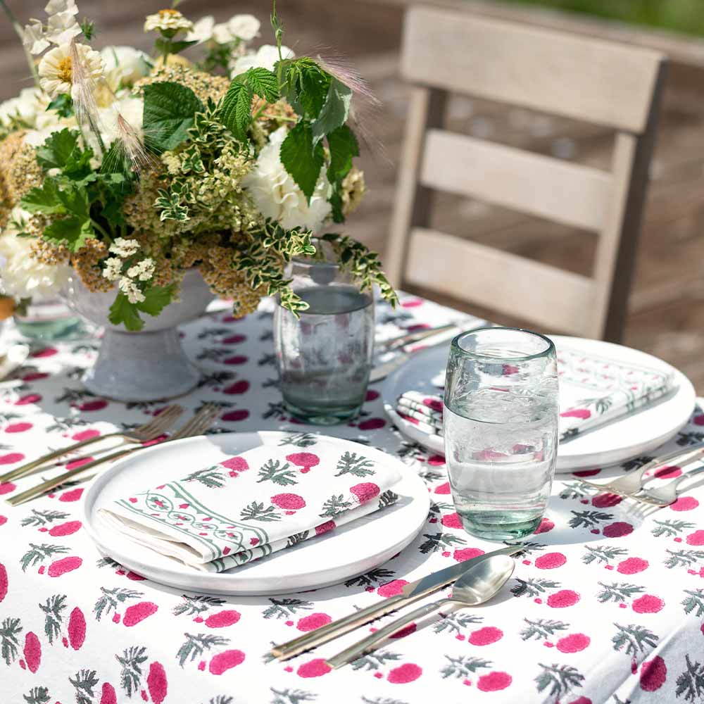 Water glasses on an outdoor table decorated with Gaya Rose tablecloth. 