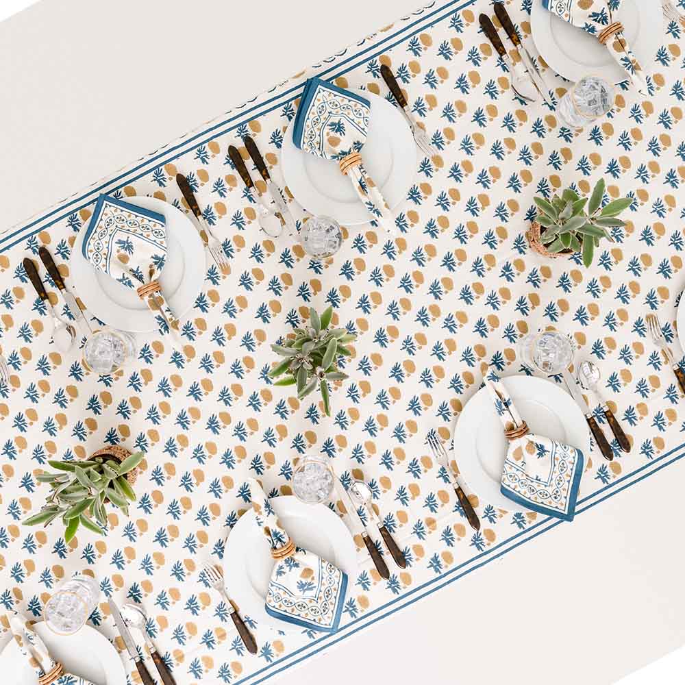 Overhead shot of tablecloth on a set dinner table with matching napkins. 