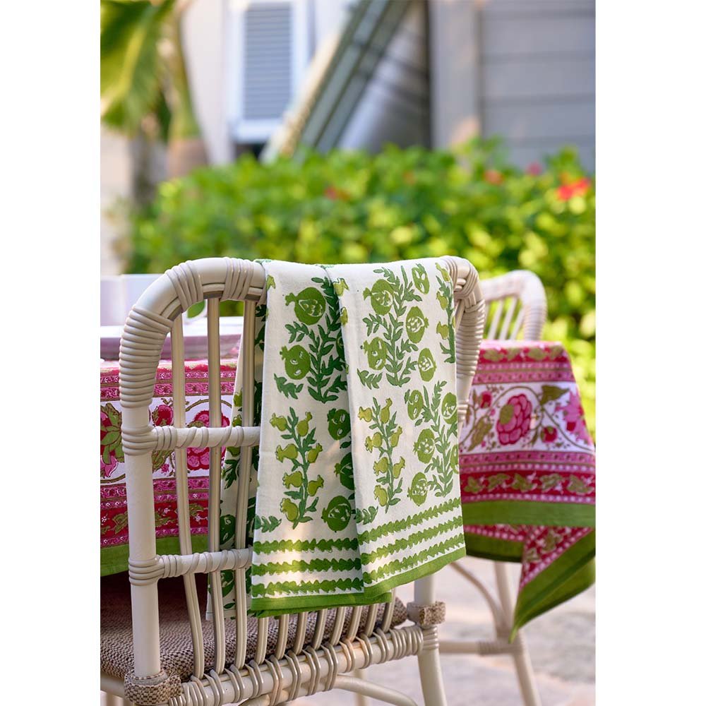 Pom Bells Green Tea Towels draped over back of wicker chair. 