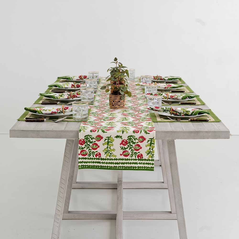 Indoor dinner table decorated with table runner and matching placemats and napkins. 