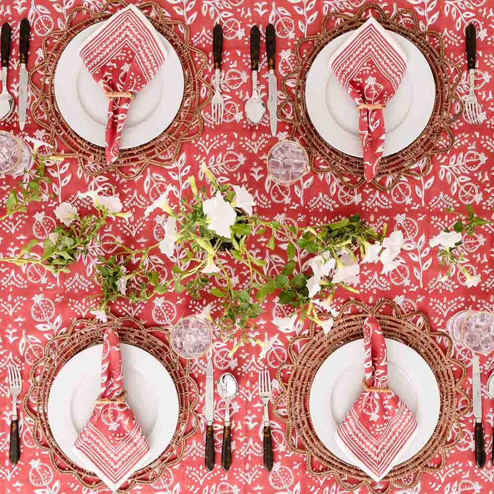 Overhead shot of Pomegranate Poppy tablecloth with matching napkins and floral decor. 