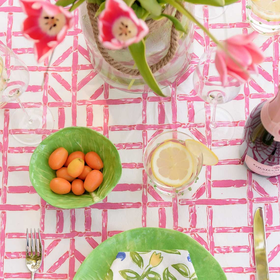 Rose Bamboo Tablecloth with pink flowers and green dishes.
