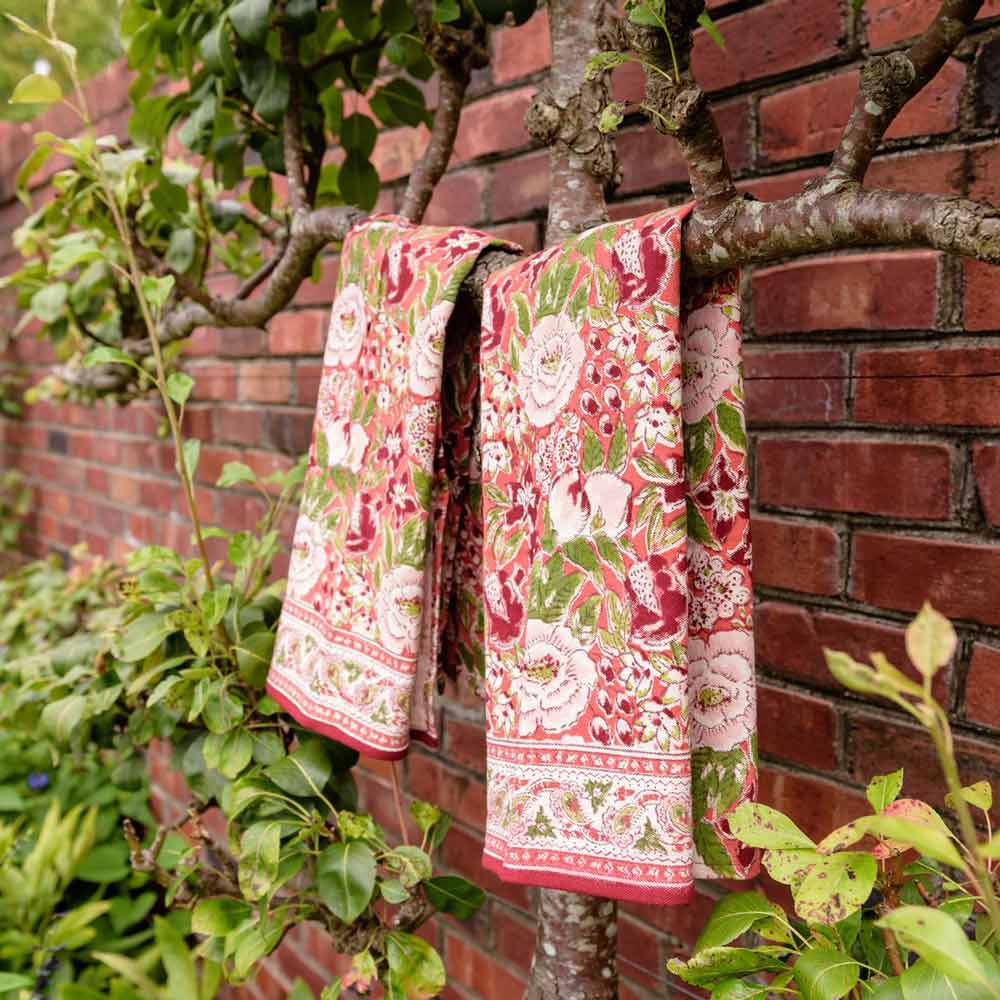 Spice Route Garnet Red Tea Towels hanging on tree.
