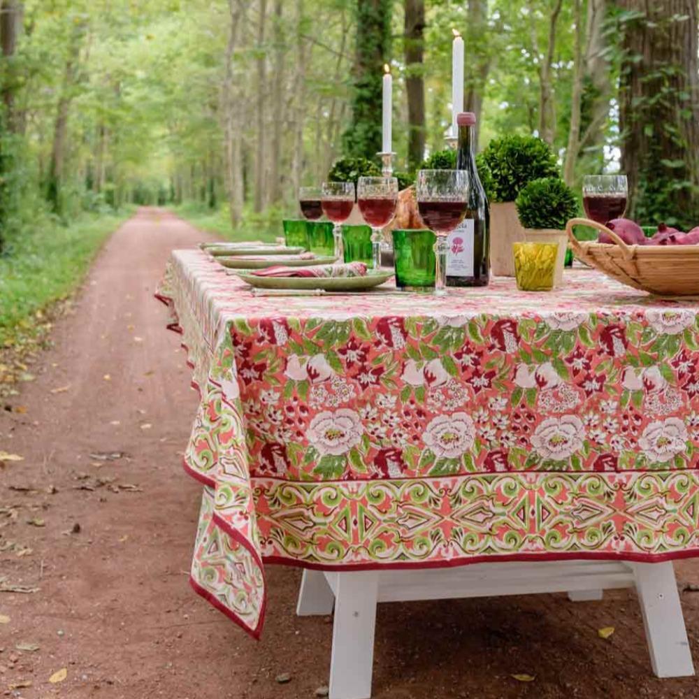 Table with Spice Route Garnet Tablecloth in woodsy setting with wine glasses.