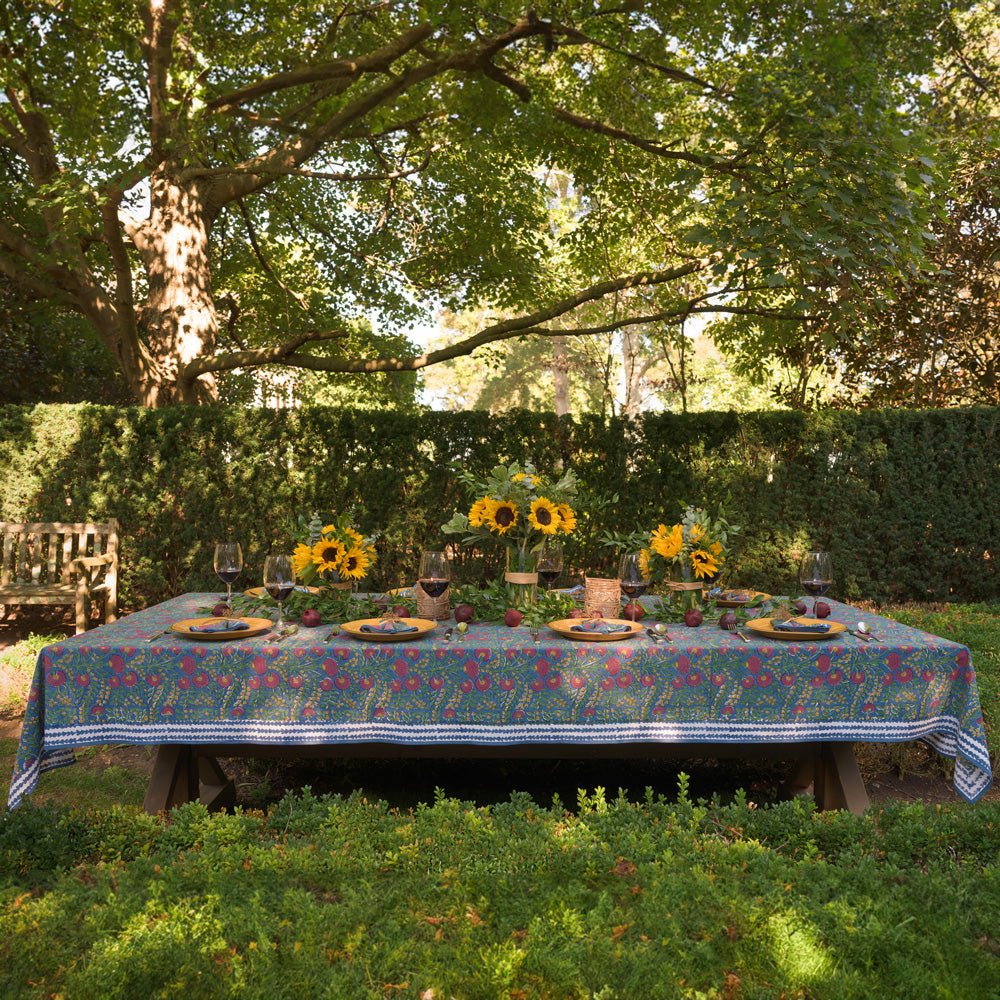 Cactus Flower Midnight Dark Blue & Magenta Floral Tablecloth outdoors set with yellow plates and sunflowers