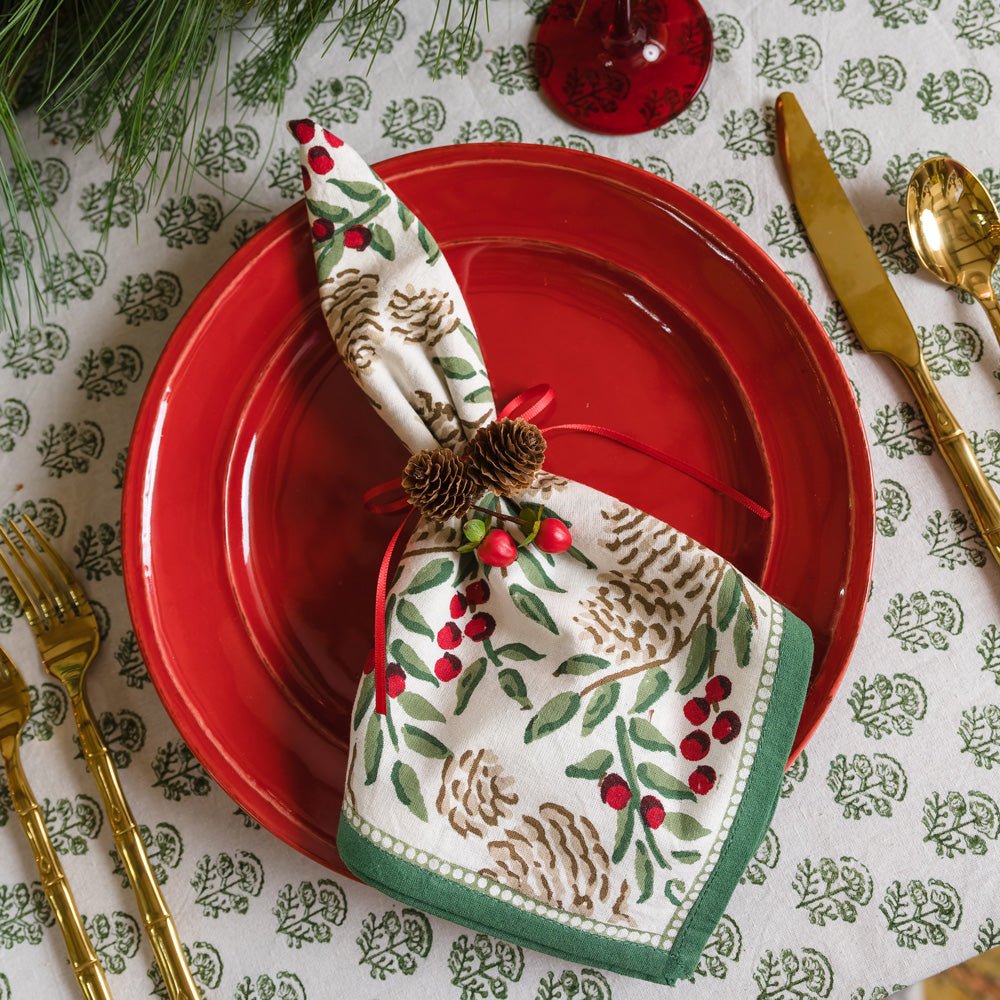 Christmas Garland Napkin on red plate with pinecones