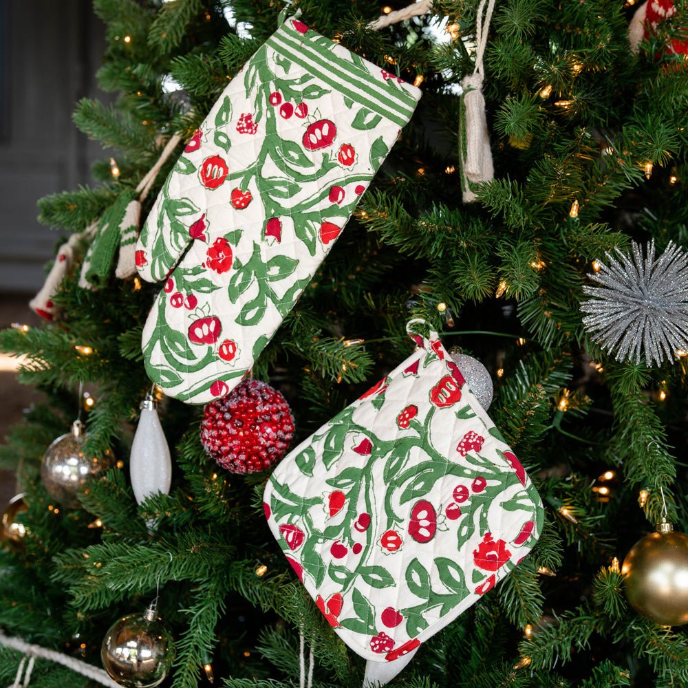 Emma Red &amp; Green oven mitt set hanging from Christmas tree branches