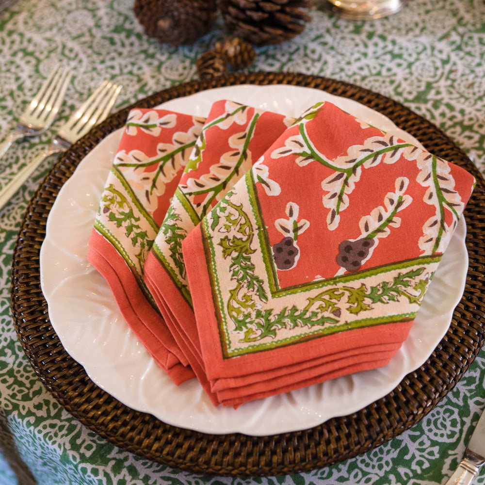Harvest Pinecone Orange & Green Napkins on white plate with dark brown charger