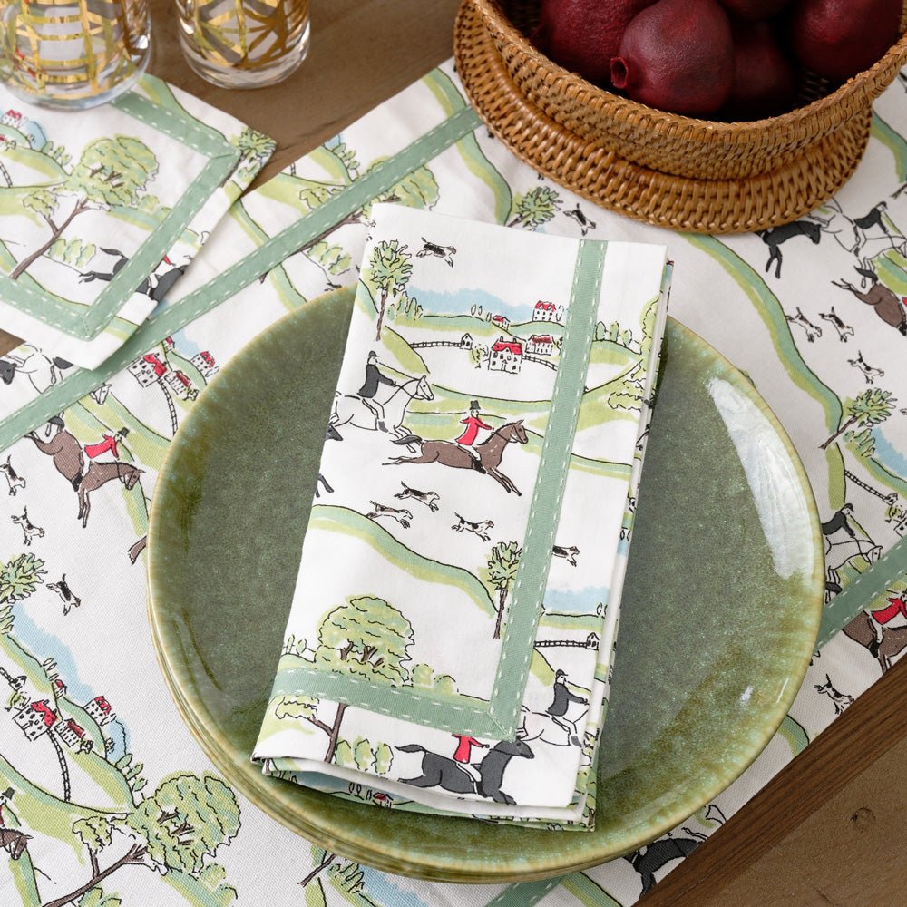 Napkin with equestrian Hunt Scene print and green ribbon on plate and matching table runner