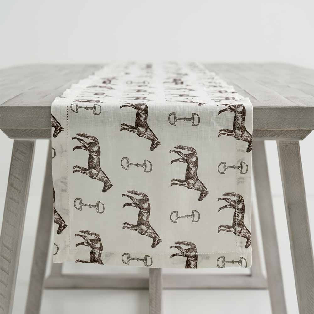 Horse and Snaffle Linen Table Runner draped over the side of a table. 