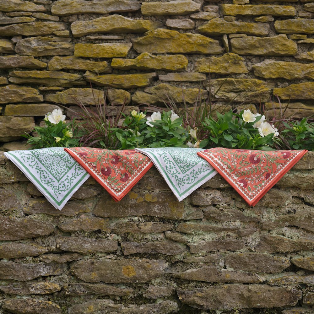 tapestry green and cactus flower red napkins hanging from stone wall
