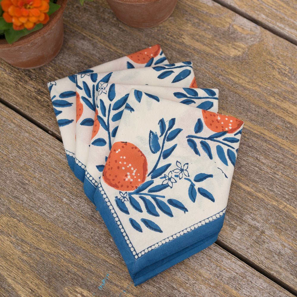 4 napkins folded as rectangles printed with blue vines and oranges