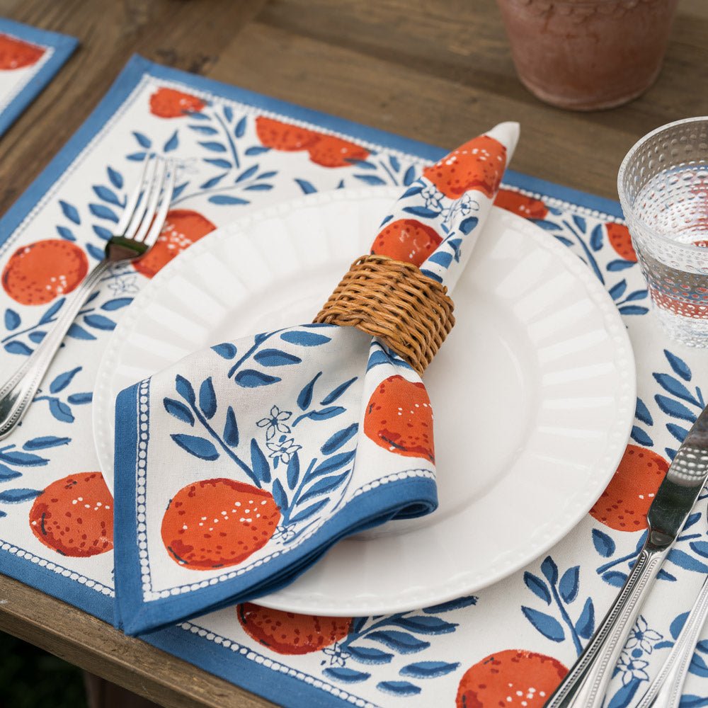 orange and blue napkin on a plate with wicker napkin ring