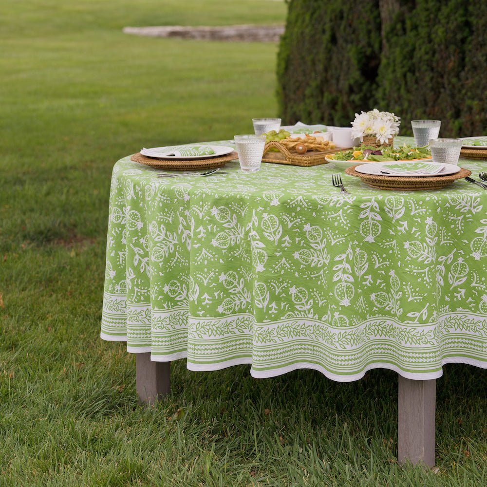 round outdoor table with pomegranate green tablecloth