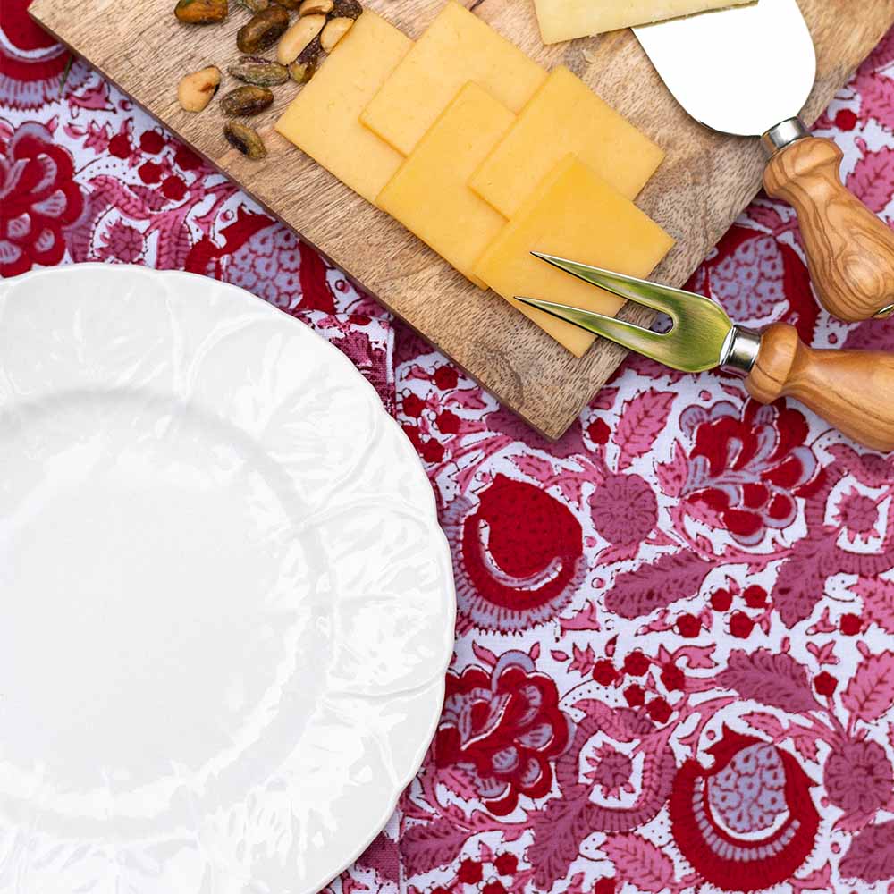 Charcuterie board on top of richly colored tablecloth. 