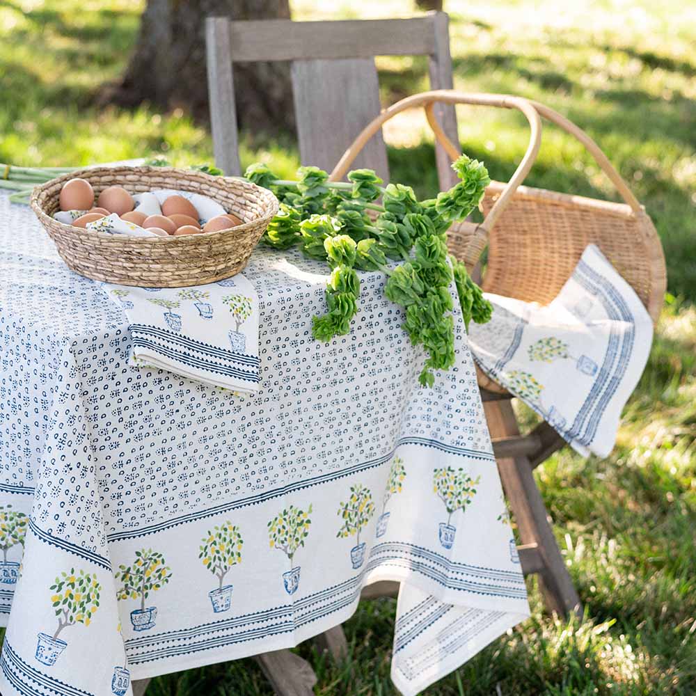 Outdoor table with tea towels in a basket with eggs. 