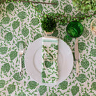 overhead of dancing artichoke green tablecloth with white plate and matching napkin