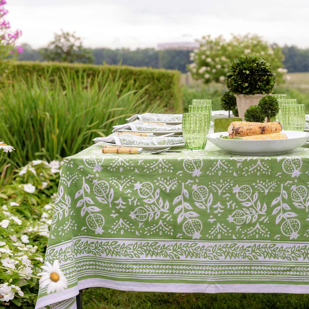 Tablecloth with green glasses and flowers. 